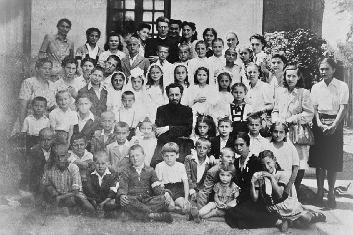 A group photograph from 1948 showing Jesuit priests, children and adults outside a building.